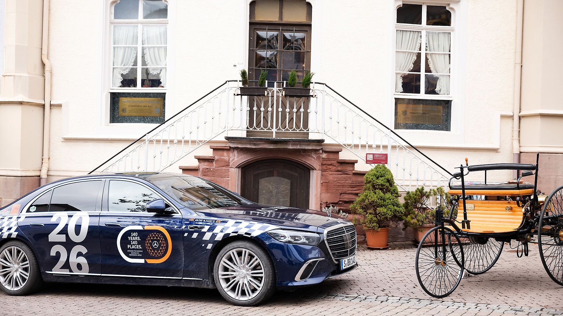 The new Mercedes-Benz S-Class together with a replica of the Benz Patent-Motorwagen in Wiesloch, Germany. Bertha Benz stopped here on the first long-distance journey in automotive history in 1888 to buy alcohol as fuel in the pharmacy. Today, the building is considered the "first gas station in the world".