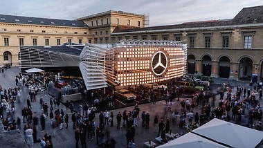 The Mercedes-Benz trade fair stand at the IAA 2025. The striking illuminated sculpture in the centre of the Apothekenhof of the Munich Residence’s courtyard represents the brand’s new iconic grille on a grand scale. 