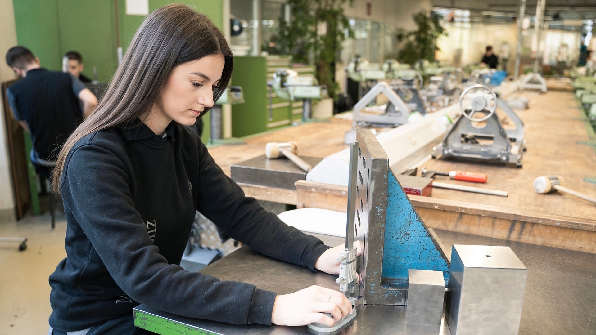 Präzision ist gefragt, wenn Tijana mit einem Höhenmessschieber die Maße der technischen Zeichnung auf dem Blech „anreißt“.