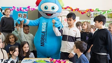 Mascot Moki visits a school class in the anniversary year.
