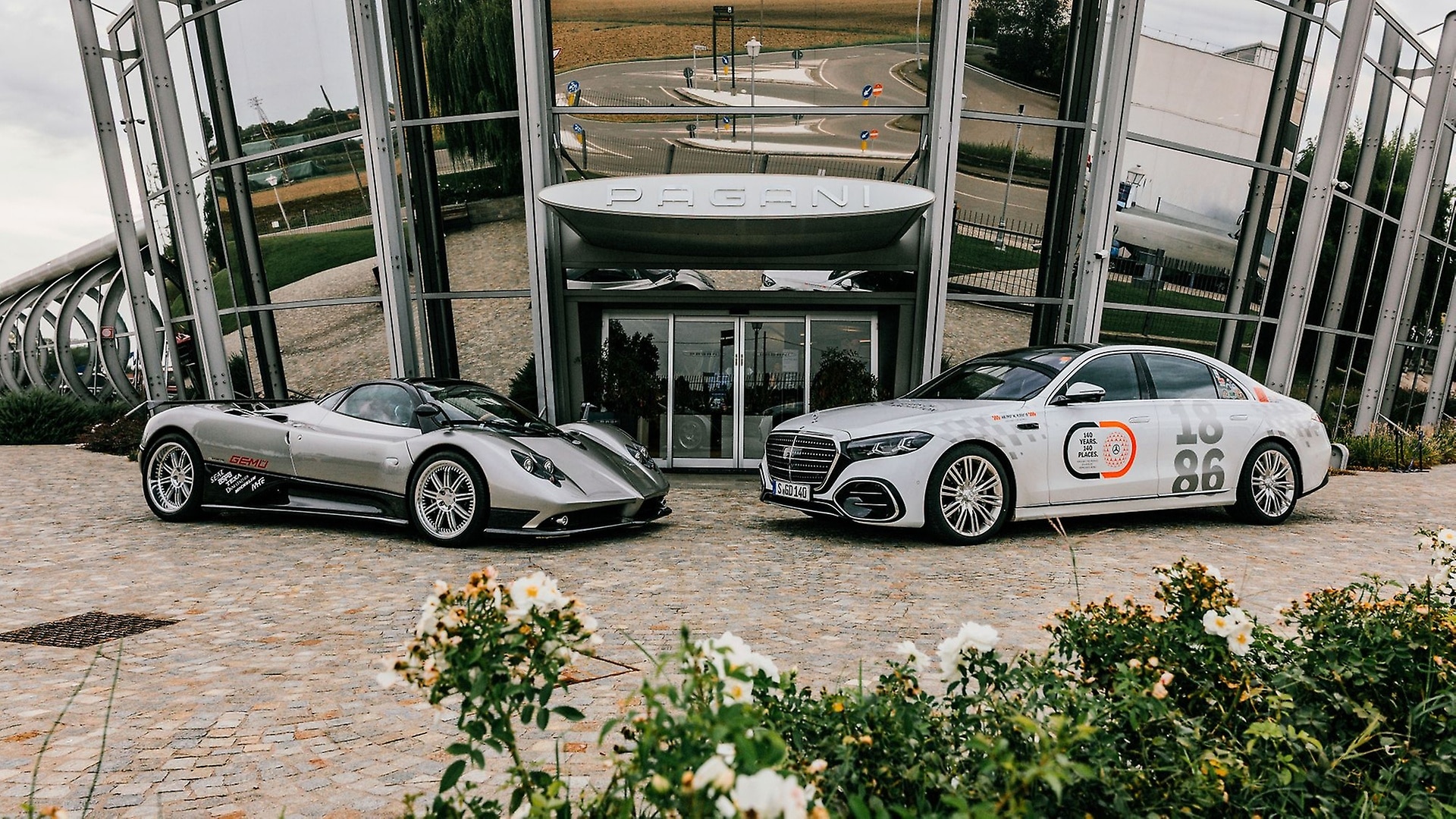 Die Mercedes-Benz S-Klasse und ein Pagandi Zonda vor dem Hauptsitz von Pagani Automobil in San Cesario sul Panaro, Italien.