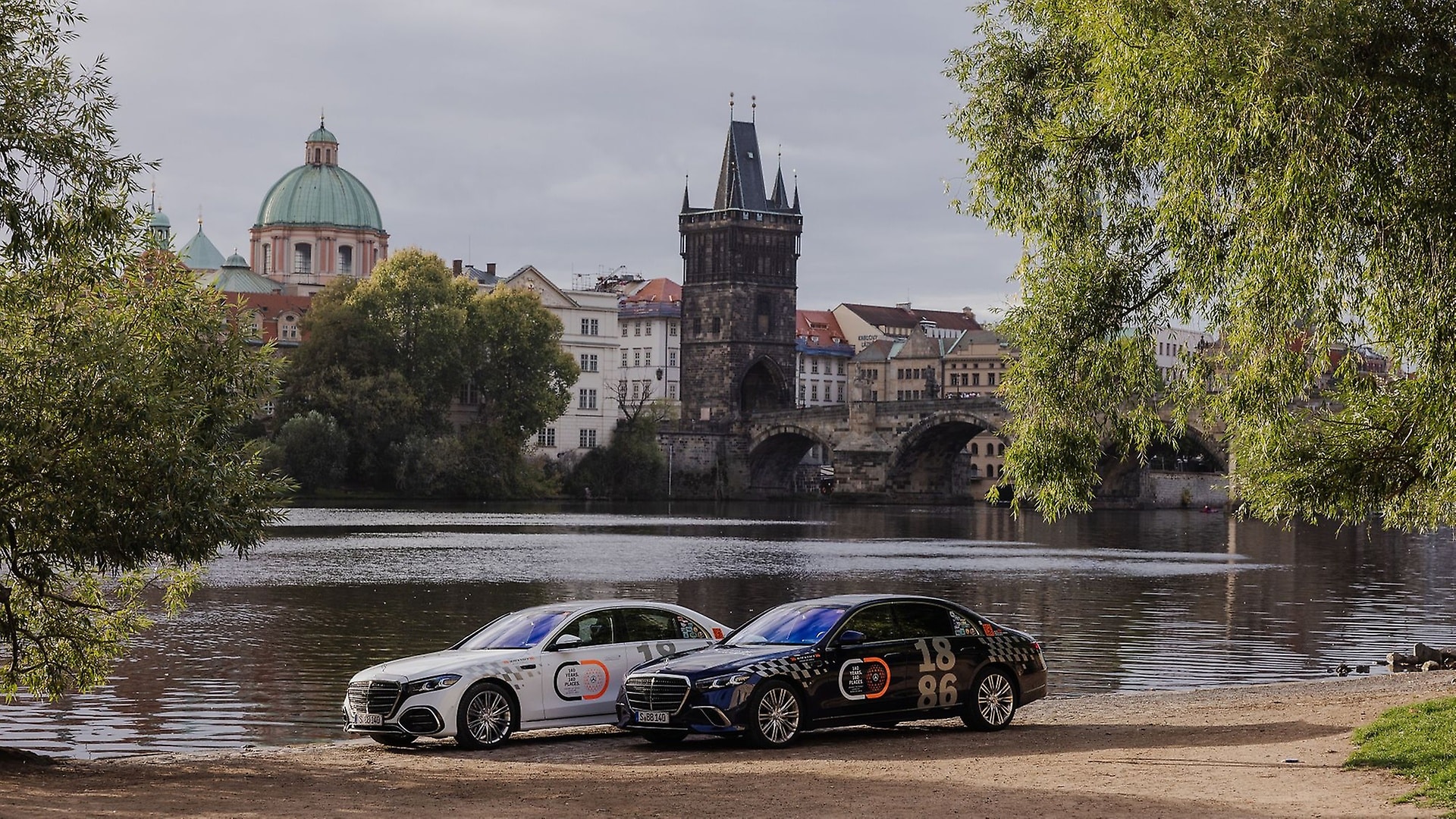 Zwei Mercedes-Benz S-Klasse Modelle vor der Kulisse der Karlsbrücke in Prag, Tschechien.