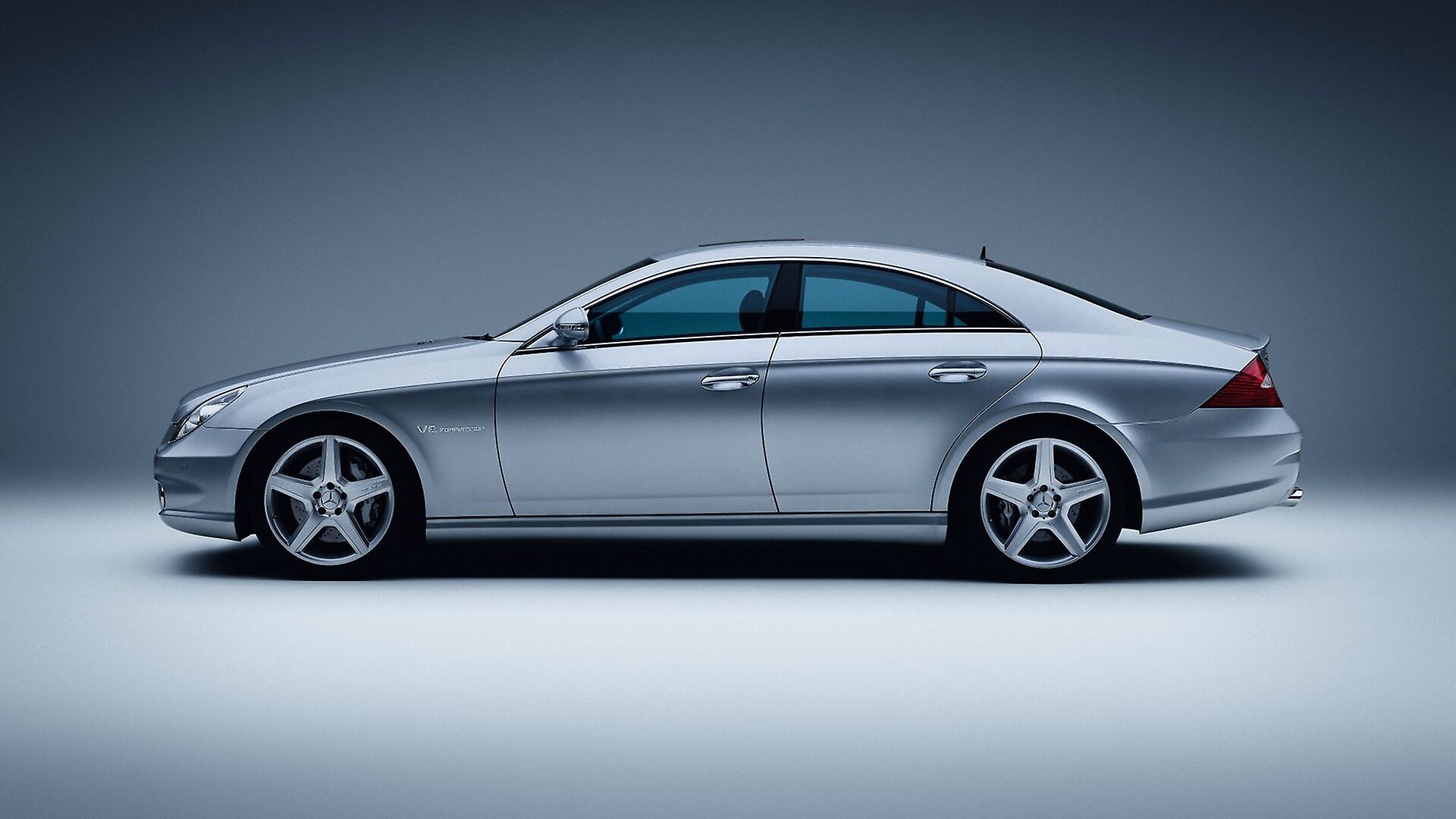 Mercedes-Benz CLS 55 AMG, Baujahr 2005 (Baureihe 219, Produktionszeit 2004 bis 2010). Studioaufnahme von links aus dem Jahr 2025.