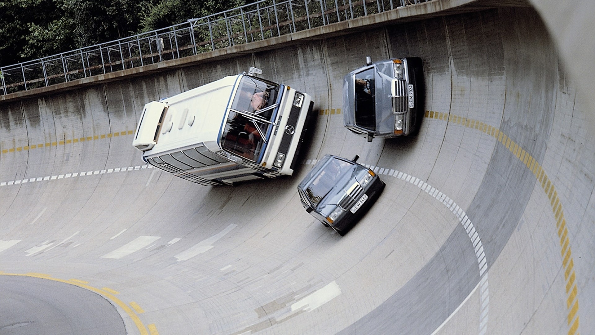 In der Steilkurve der Einfahrbahn des Werks Untertürkheim: Mercedes-Benz Limousine der Baureihe 201, S-Klasse-Limousine der Baureihe 126 und ein O 303 Reise-Omnibus, 1984.