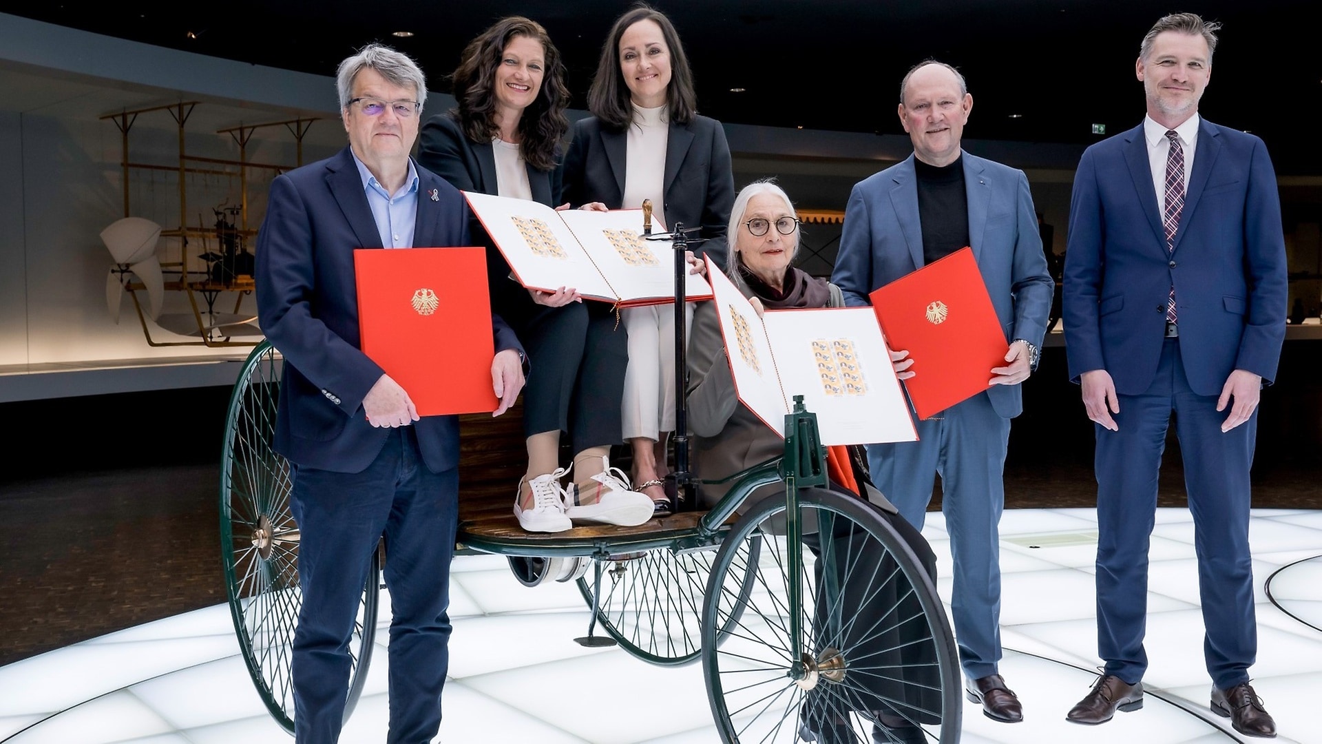 Handover of scrapbooks from Fabian Leber (spokesman for the Federal Minister of Finance) to Marcus Breitschwerdt (head of Mercedes-Benz Heritage GmbH), Jutta Benz (great-granddaughter of Bertha and Carl Benz), Bettina Haussmann (director of Mercedes-Benz Museum), Alexandra Süß (head of Mercedes-Benz Classic Archive and collection) and Reinhard Houben (member of the German Bundestag and member of the program advisory board for special postage stamps).